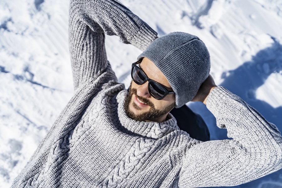 Nasmiješeni muškarac sa sunčanim naočalama na snijegu