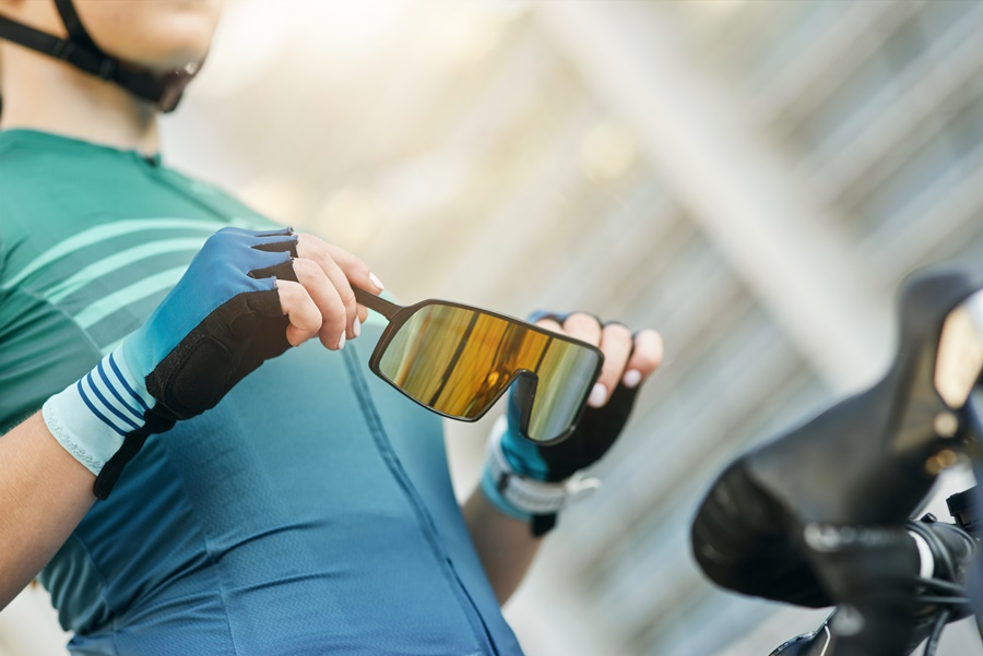 Muškarac koji se bavi bicikliranjem drži polarizirane sunčane naočale