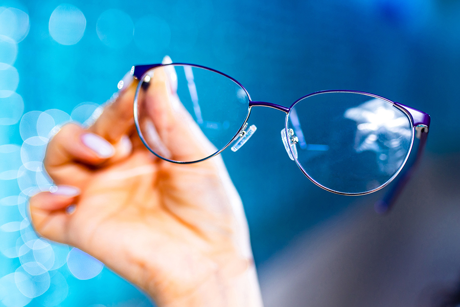 Ženska osoba drži dioptrijske naočale u ruci